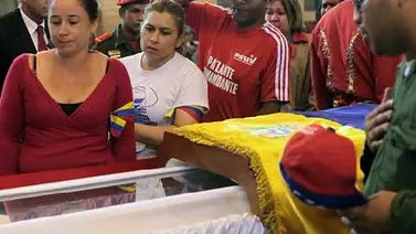 AFP: Chávez viste traje verde olivo con corbata negra y porta la banda de la Milicia en el féretro AFP: Chávez viste traje verde olivo con corbata negra y porta la banda de la Milicia en el féretro