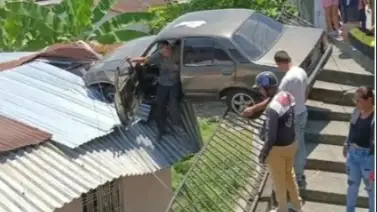 Un vehículo queda clavado en el techo de una casa tras perder el control Un vehículo queda clavado en el techo de una casa tras perder el control
